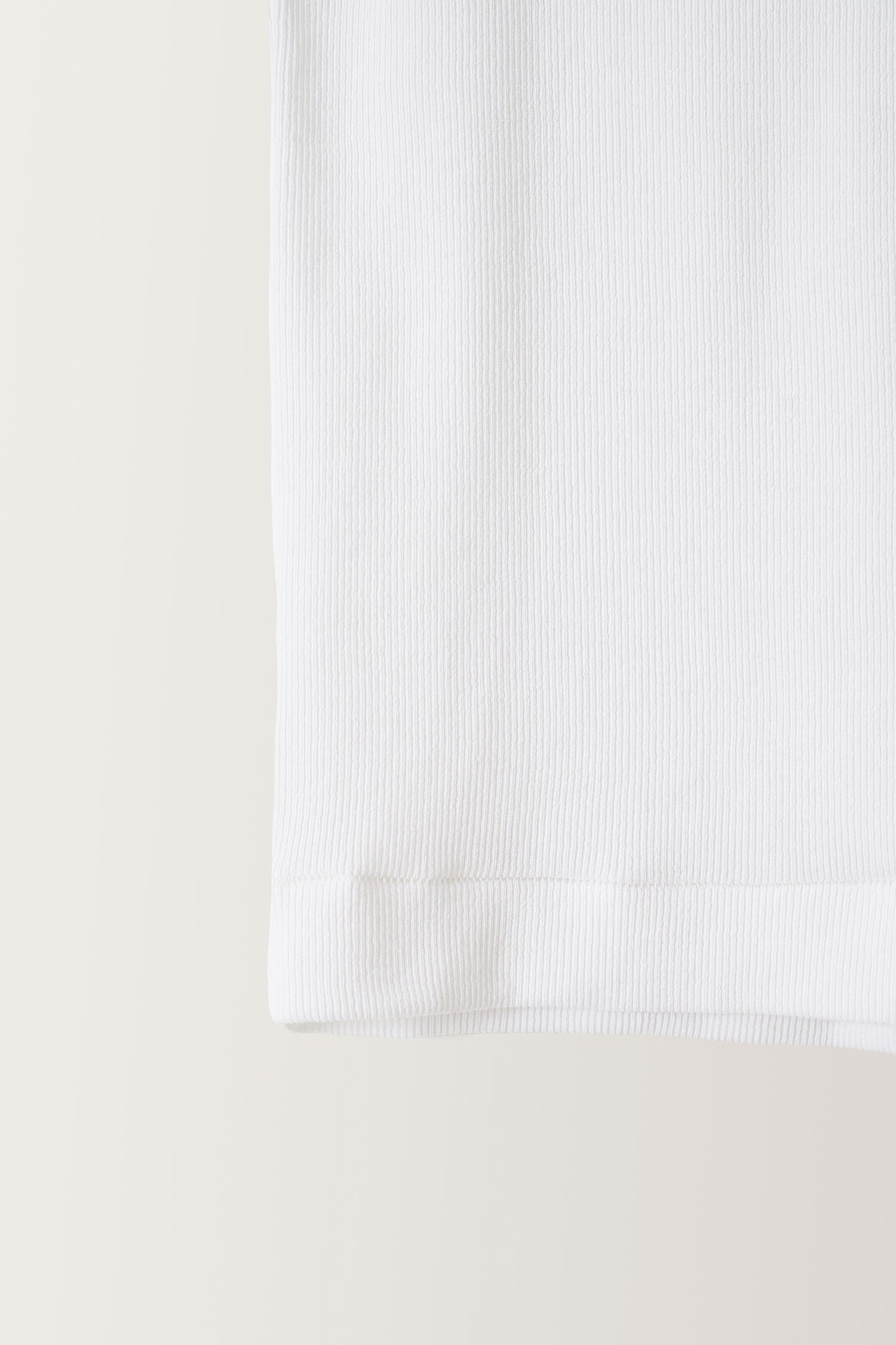 Close-up of ribbed cotton texture on Nothing Written white tank top