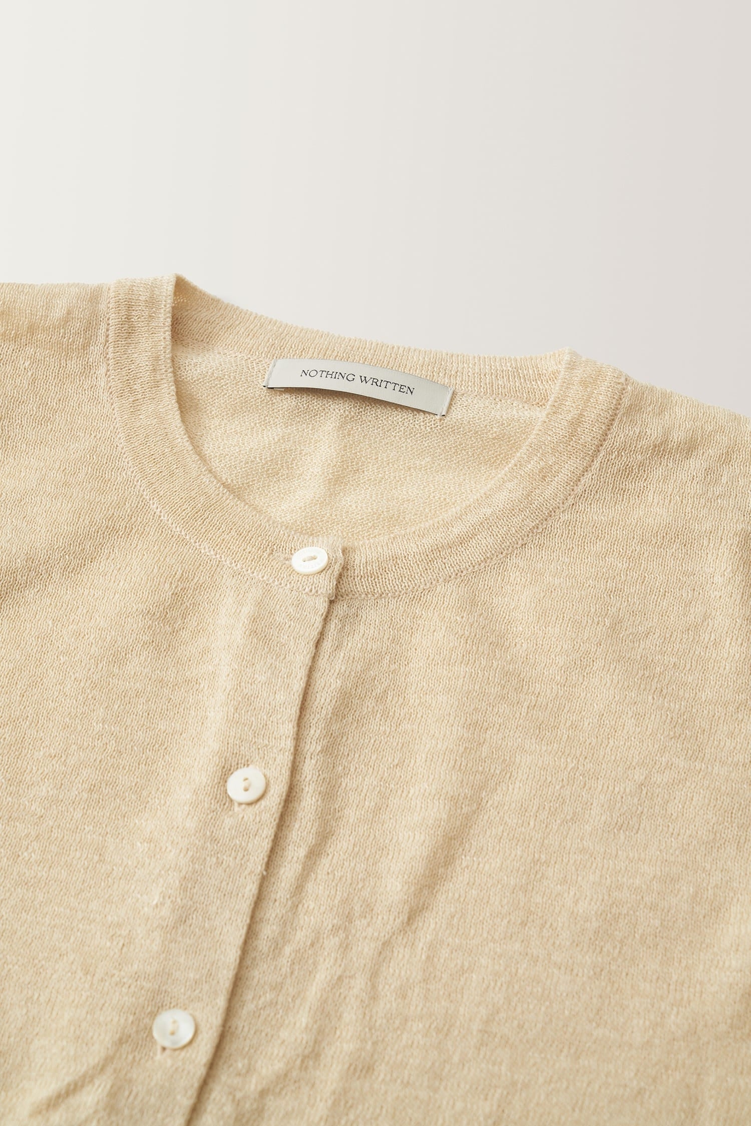 Detail of neckline and buttons on Nothing Written yellow linen cardigan
