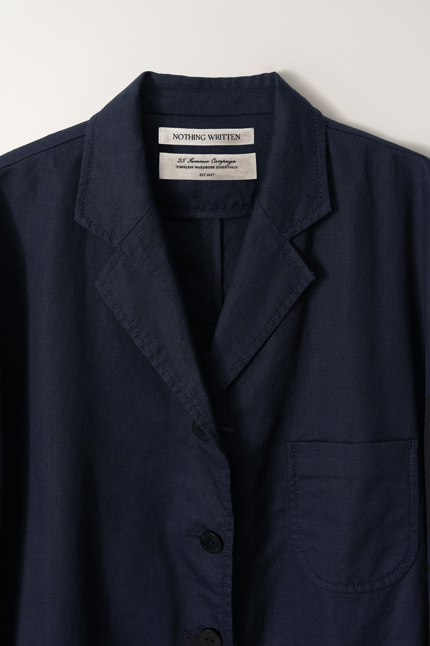 Detail of collar and inner label on Nothing Written navy oversized linen jacket