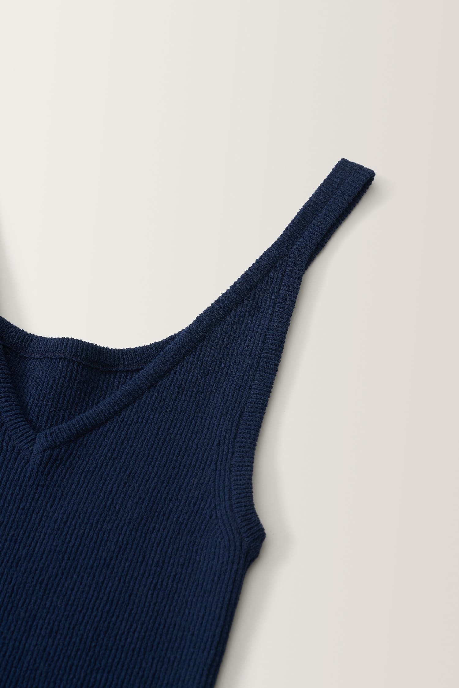 Detail of V-neckline and strap on Nothing Written navy knit top