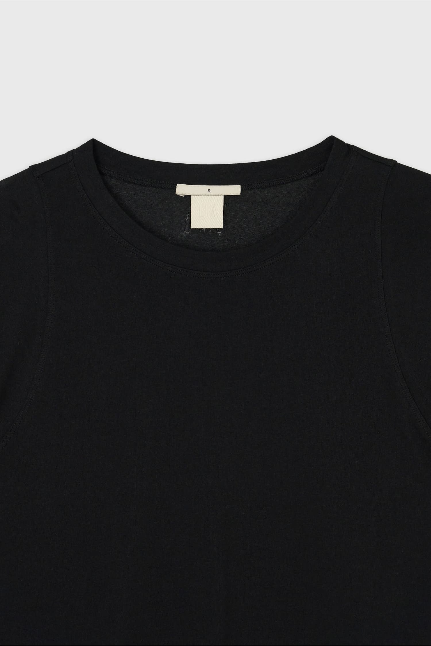 Close-up of round neckline and label on The Loom black cotton T-shirt