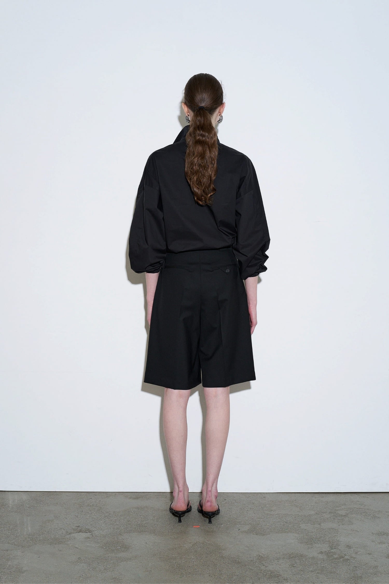 The Loom black drawstring neck jacket back view with elastic cuffs and clean silhouette