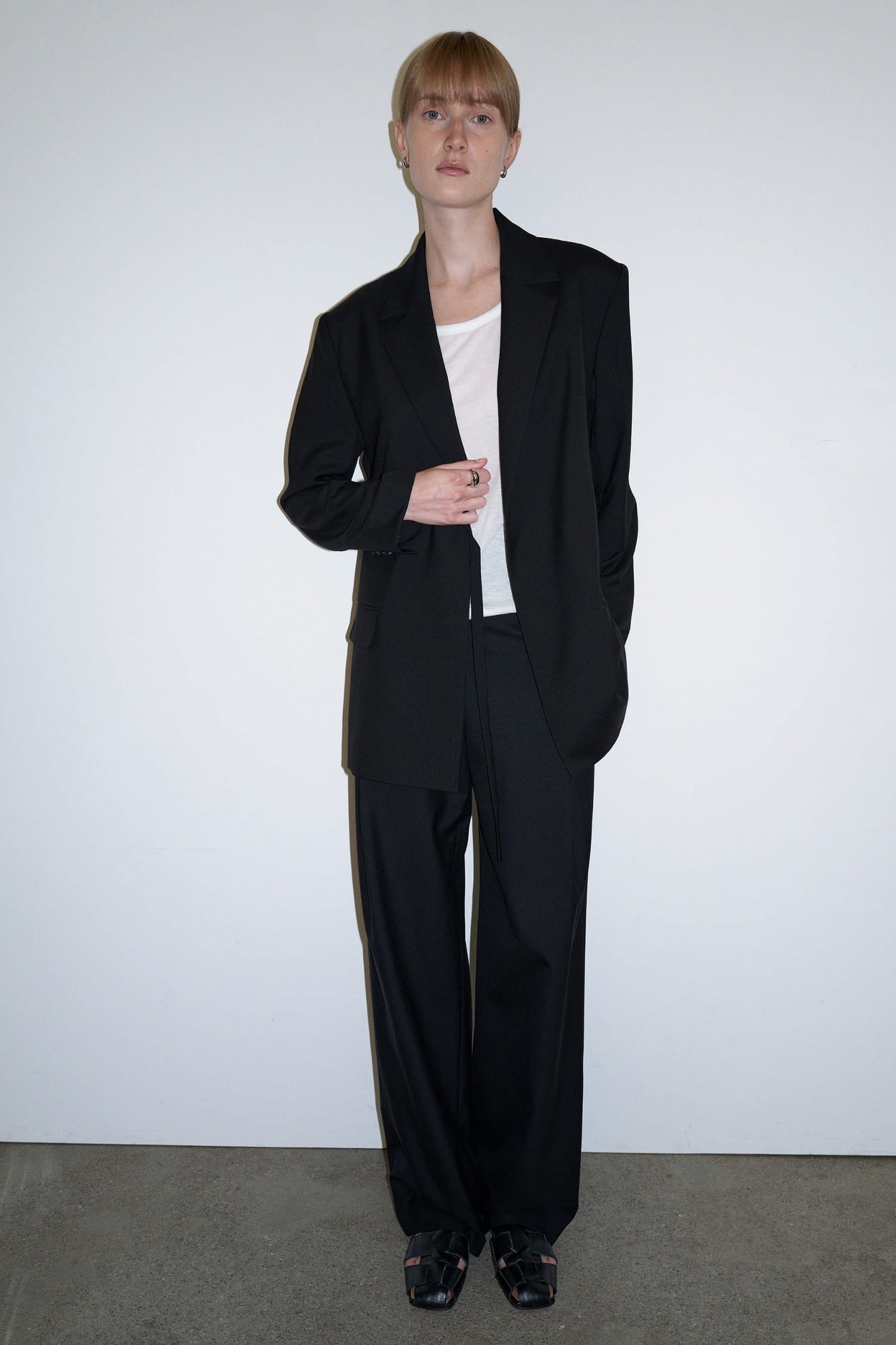 Close-up of The Loom black tailored trousers showing high waist and clean front construction