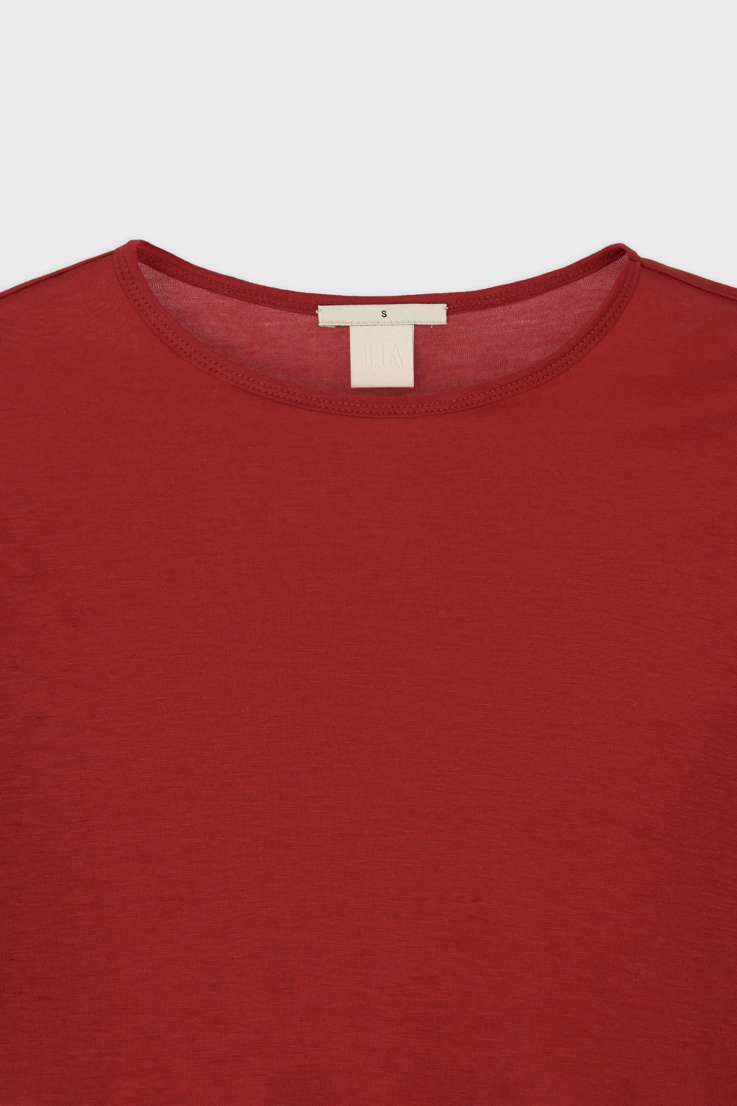 Close-up of round neckline and soft cotton fabric on The Loom red long sleeve t-shirt