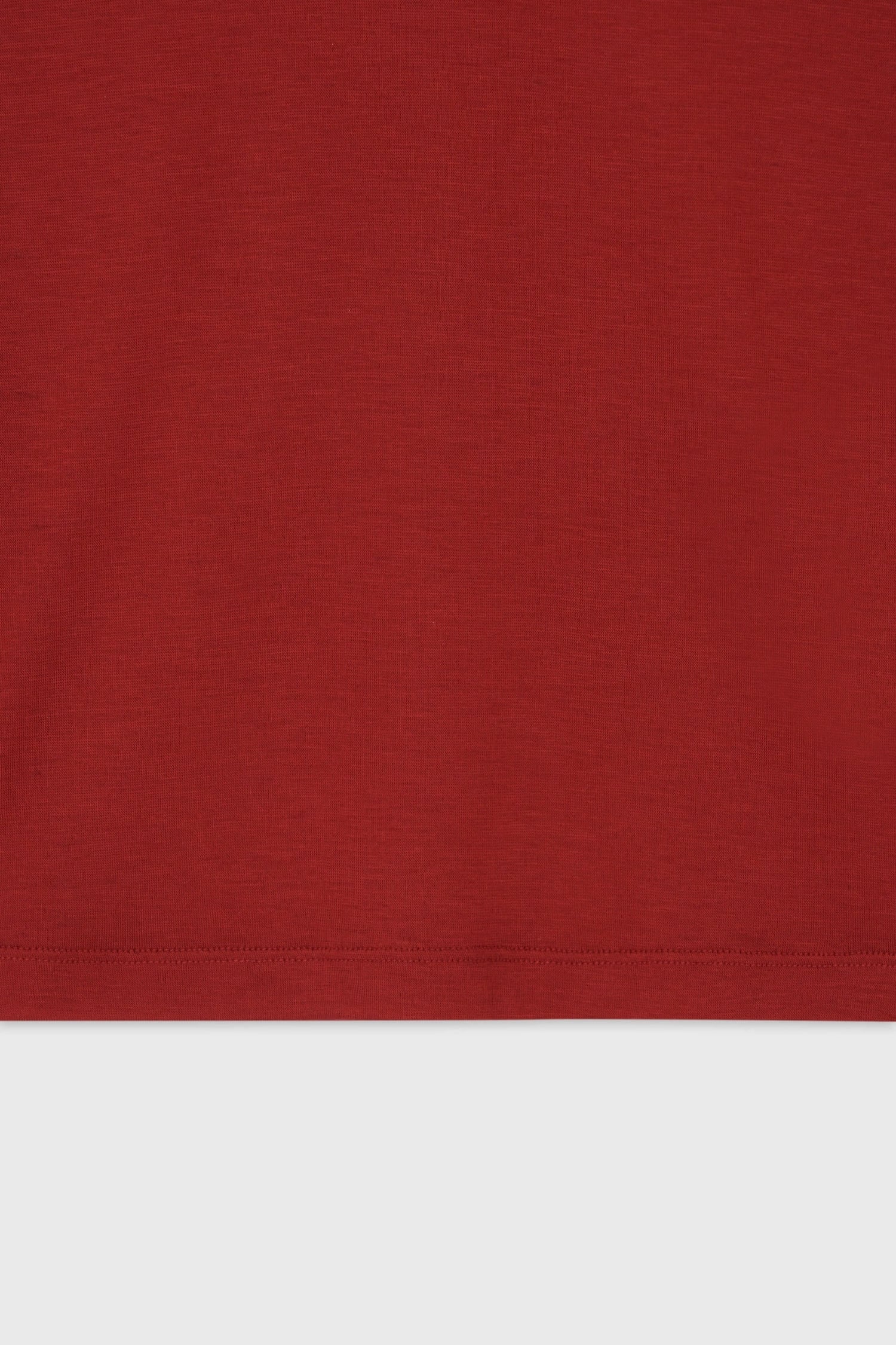 Detail of hem finish and lightweight cotton texture on The Loom red long sleeved t-shirt