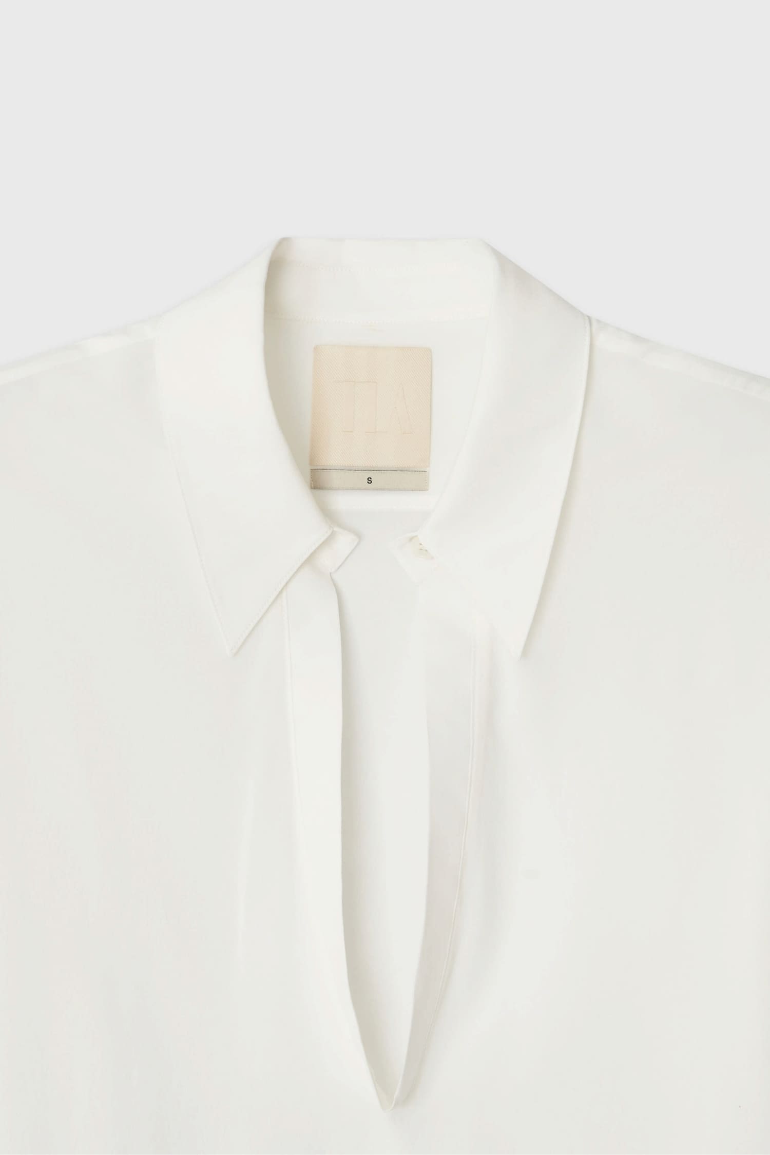 Detail of collar on The Loom white silk open shirt