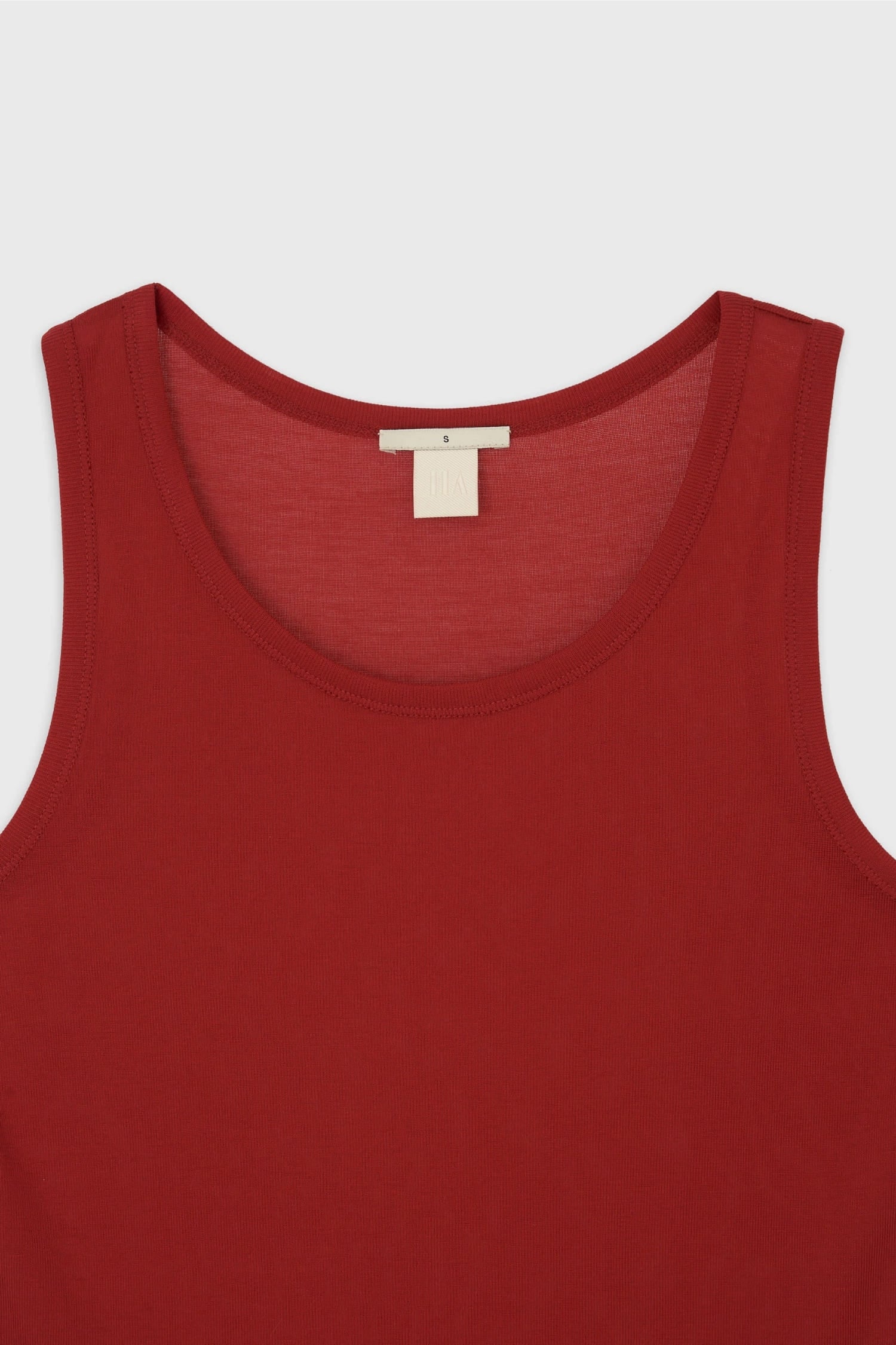 Detail of round neckline and fine cotton texture on The Loom red sleeveless top