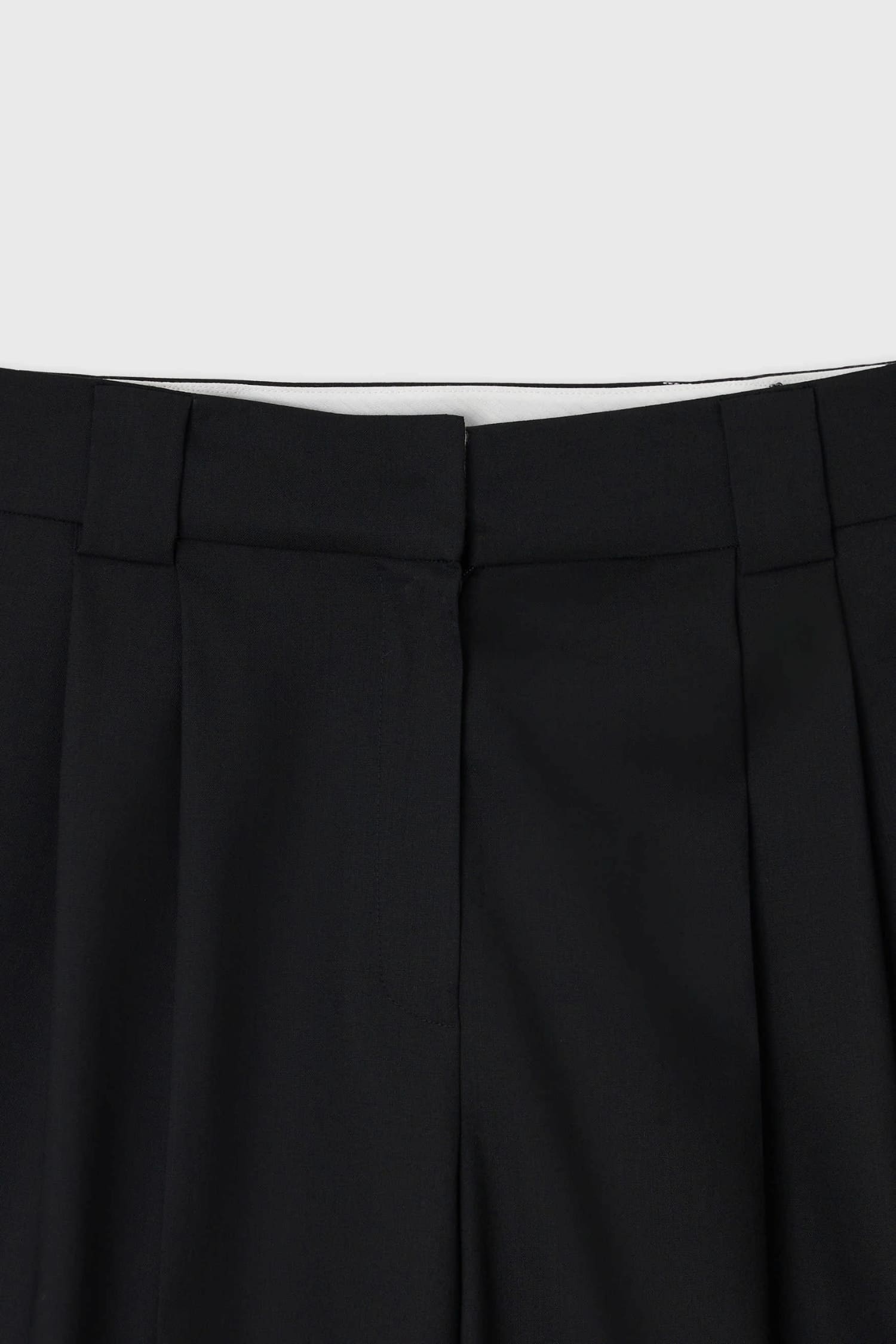 Close-up of waistband detail on The Loom black summer wool tailored shorts