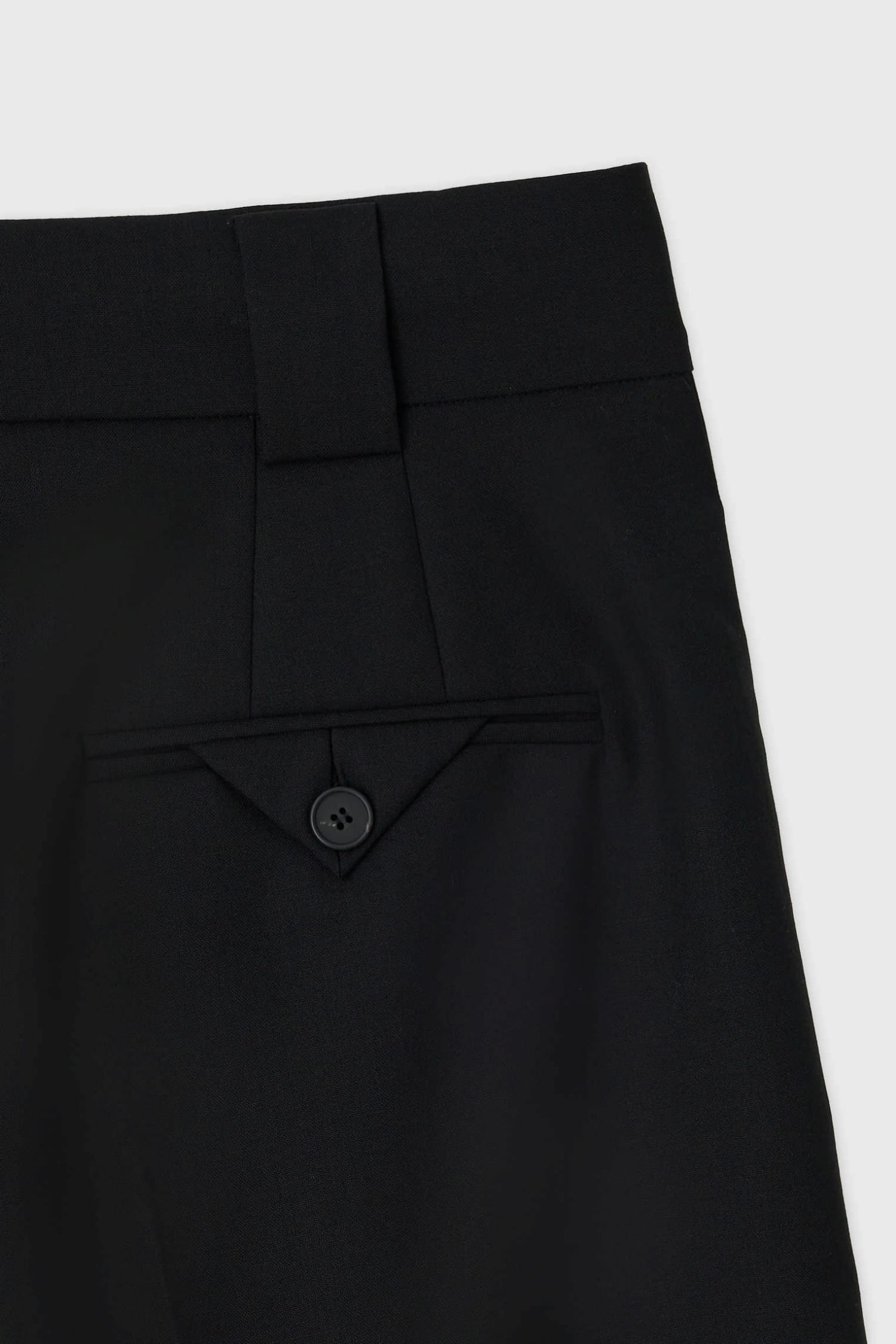 Back pocket detail with button closure on The Loom black tailored summer wool shorts