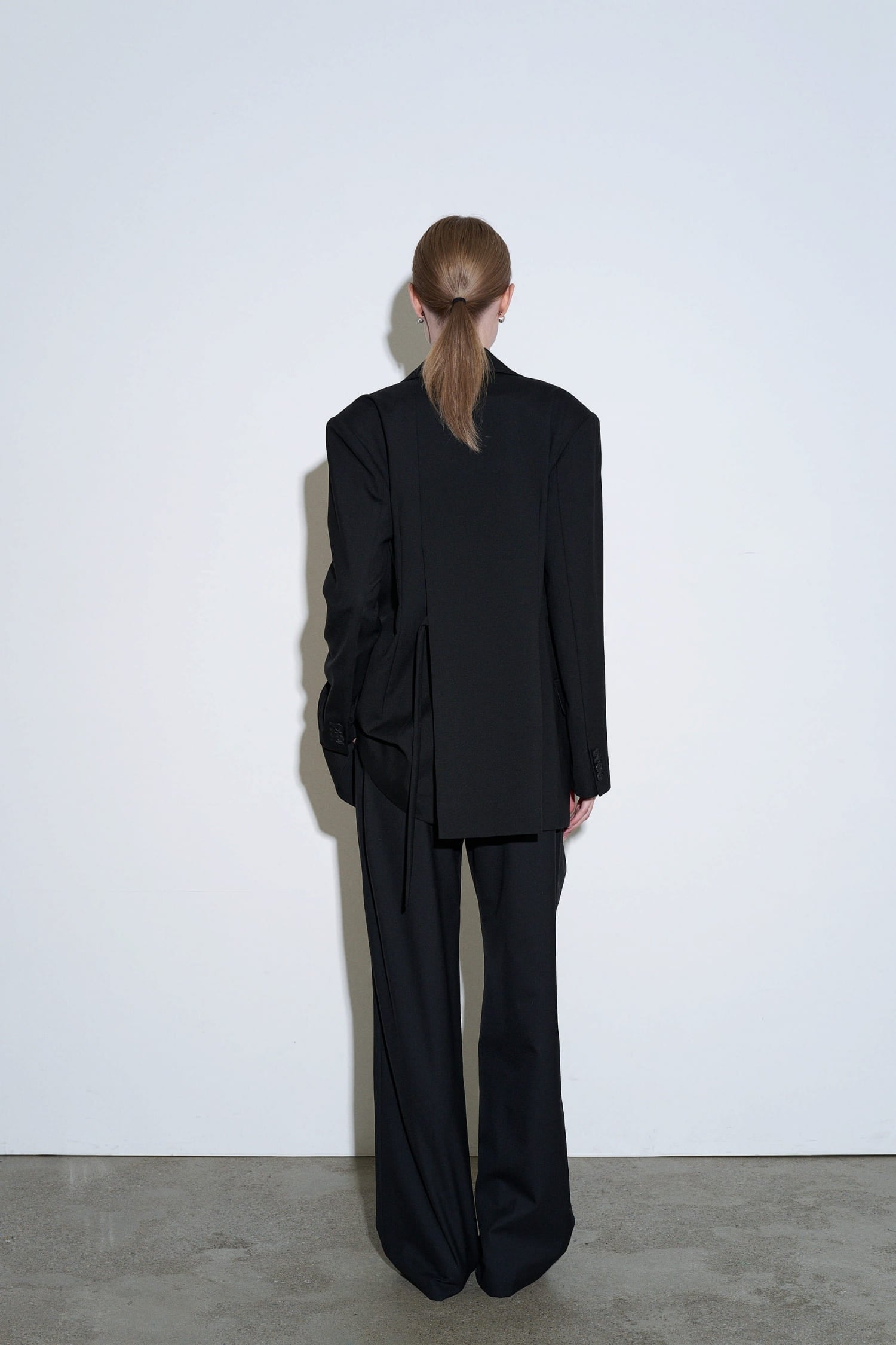The Loom black wool tie jacket back view with clean straight cut and structured shoulders