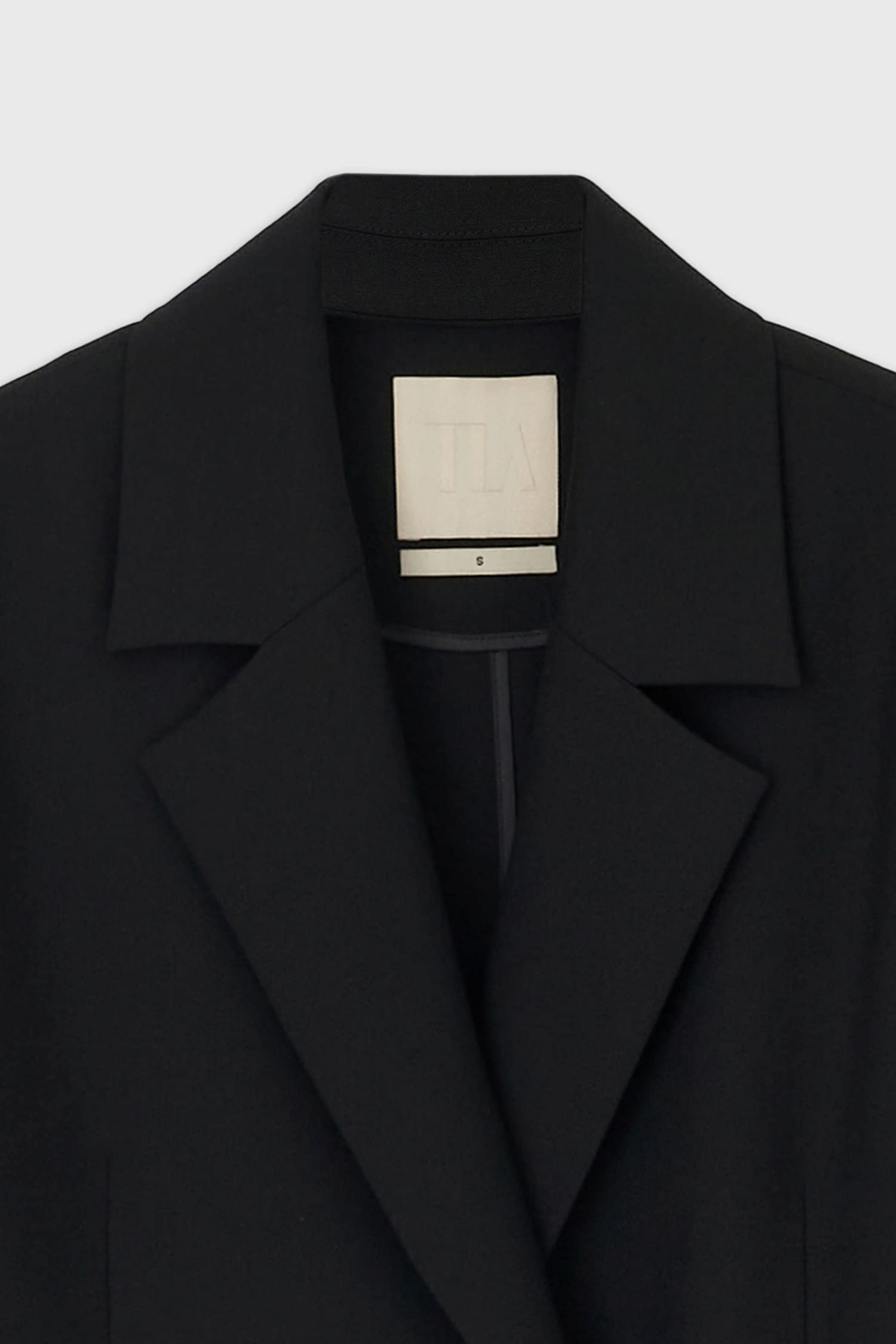 Close-up of notch lapel and inner label on The Loom black wool jacket